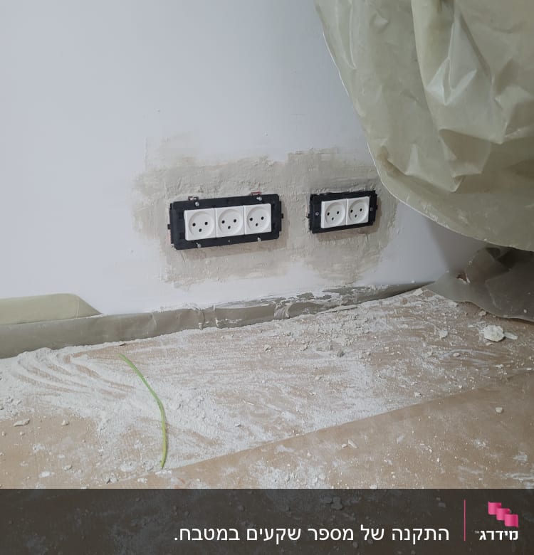 שקעי חשמל מותקנים בקיר עם טיח מסביב